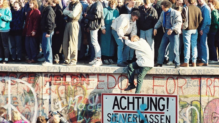 Crowds atop the Berlin Wall at the Brandenburg Gate on 9 November 1989, the night the Wall fell and Germany moved toward reunification