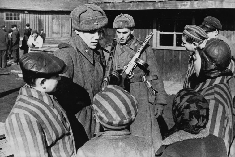 Soviet Army soldiers speaking with children liberated from Auschwitz concentration camp, January 1945