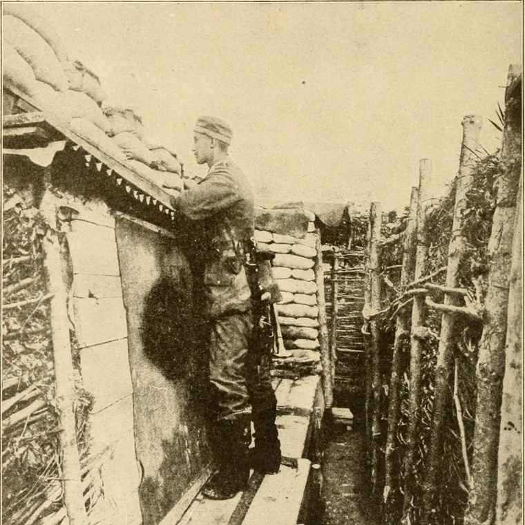 Soldiers resting in a muddy, waterlogged trench during World War 1, surrounded by sandbags and wooden supports
