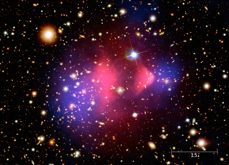 What is dark matter? The Bullet Cluster — two colliding galaxy clusters where dark matter (blue overlay) separated from hot gas (pink, X-ray) during the collision, providing direct evidence for dark matter