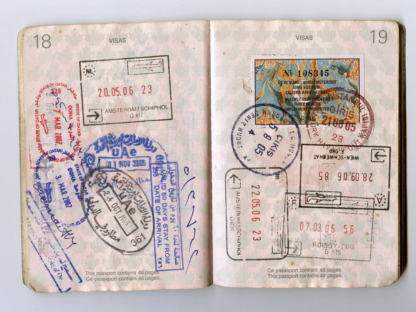 An open passport full of entry and exit stamps from several countries